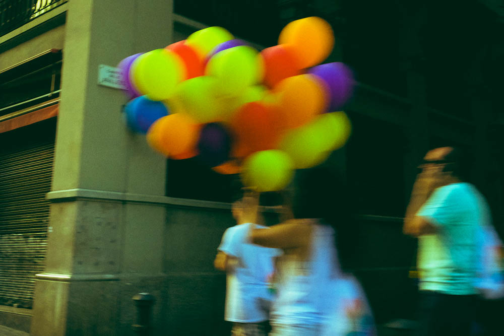 Woman with colourful balloons walking the streets