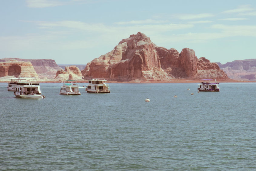 boats on lake with red mountains