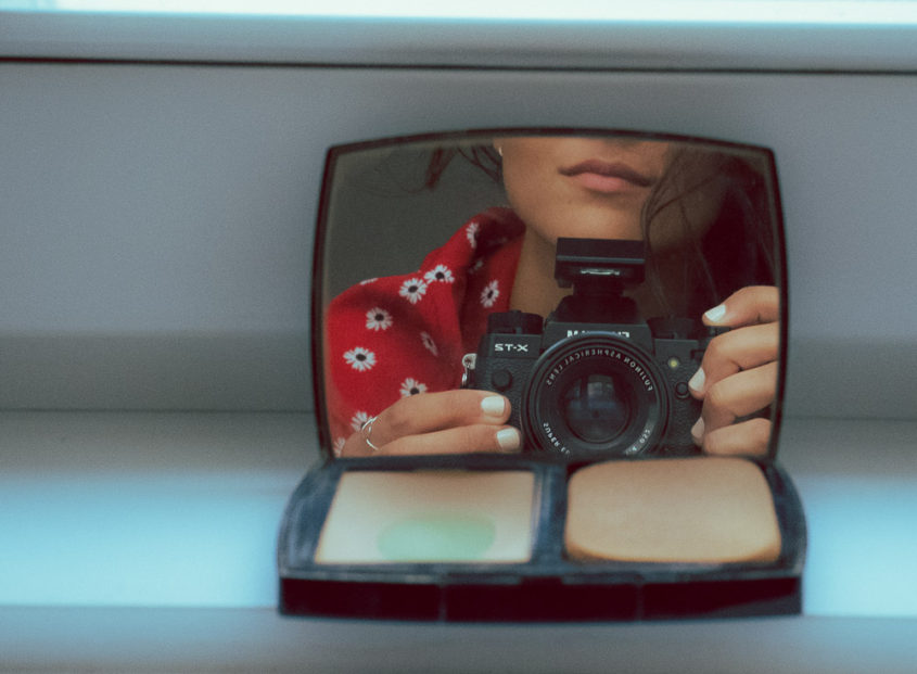 girl holding a camera in a mirror