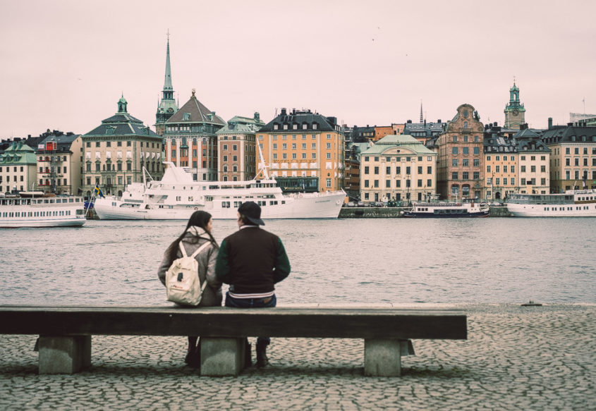 couple on a bench looking at the water and the view of Stockholm